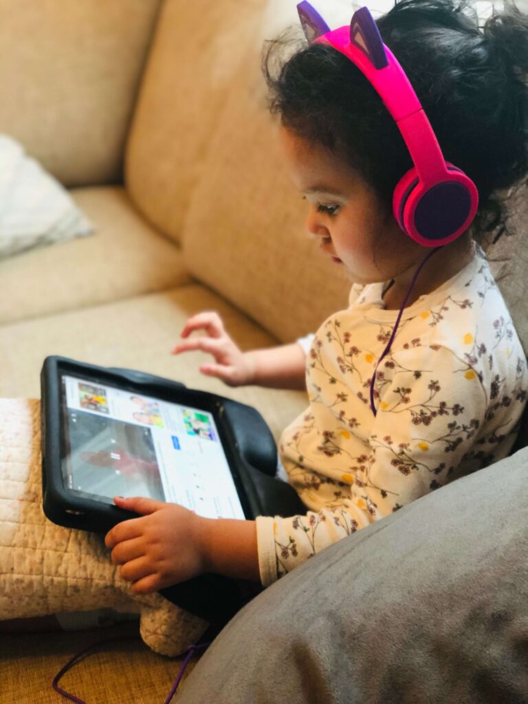 child playing with edtech on tablet