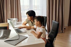 girl and mom playing with edtech on laptop